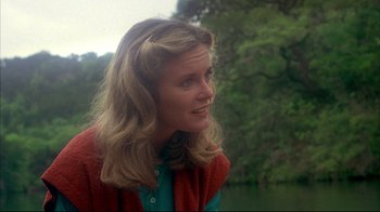 Movie still from “Piranha” (1978), directed by Joe Dante – A woman with long blonde hair wearing a red sweater; Close Up shot, Over the shoulder angle