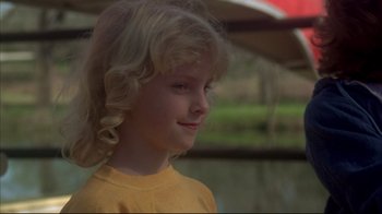 Movie still from “Piranha” (1978), directed by Joe Dante – A little girl in a yellow shirt is smiling; Close Up shot, Low angle