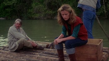 Movie still from “Piranha” (1978), directed by Joe Dante – A woman sitting on a boat next to a man; Wide shot, High angle