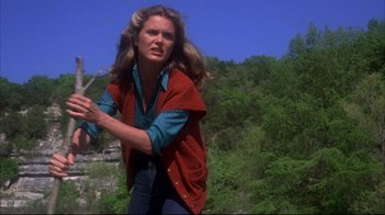 Movie still from “Piranha” (1978), directed by Joe Dante – A woman swinging a baseball bat on a field; Medium shot, Low angle