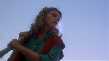 Movie still from “Piranha” (1978), directed by Joe Dante – A woman with long blonde hair holding a microphone; Close Up shot, Low angle