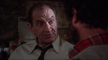 Movie still from “Piranha” (1978), directed by Joe Dante – An older man wearing a neck tie talking to a younger man; Close Up shot, Over the shoulder angle