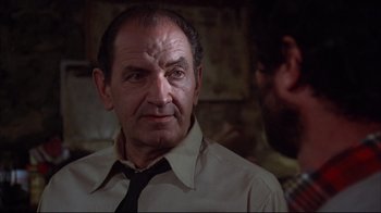 Movie still from “Piranha” (1978), directed by Joe Dante – An older man wearing a neck tie in a room; Close Up shot, Low angle