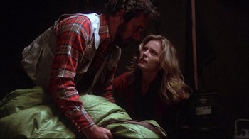 Movie still from “Piranha” (1978), directed by Joe Dante – A man and a woman looking at each other while sitting on a bed; Medium shot, Low angle