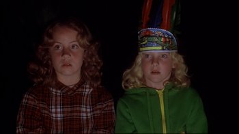 Movie still from “Piranha” (1978), directed by Joe Dante – Two young girls are watching something on a television screen; Close Up shot, Low angle