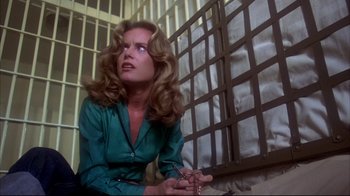 Movie still from “Piranha” (1978), directed by Joe Dante – A woman sitting in front of a window in a jail cell; Medium shot, Low angle