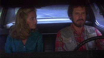 Movie still from “Piranha” (1978), directed by Joe Dante – A man and a woman sitting in the back of a car; Medium shot, Low angle