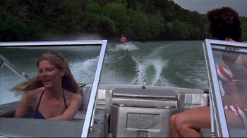 Movie still from “Piranha” (1978), directed by Joe Dante – A person is water skiing behind a boat on the water; Wide shot, Low angle