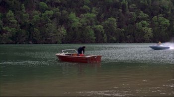 Movie still from “Piranha” (1978), directed by Joe Dante – A man in a boat in the water; Extreme Wide shot, High angle