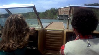 Movie still from “Piranha” (1978), directed by Joe Dante – Two people on a boat in the water; Wide shot, Over the shoulder angle