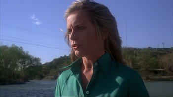 Movie still from “Piranha” (1978), directed by Joe Dante – A woman wearing a green shirt standing next to a body of water; Close Up shot, Low angle