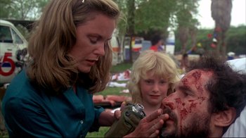 Movie still from “Piranha” (1978), directed by Joe Dante – A woman and a child looking at a man's face with blood on it; Close Up shot, Over the shoulder angle