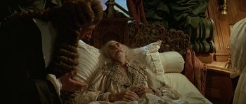 Movie still from “Pirates” (1986), directed by Roman Polanski – An old man is lying in a bed with a woman; Medium shot, High angle