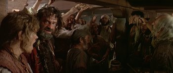 Movie still from “Pirates” (1986), directed by Roman Polanski – A group of men standing around in a room; Medium shot, Over the shoulder angle