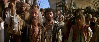 Movie still from “Pirates” (1986), directed by Roman Polanski – A large group of men standing next to each other on a boat; Medium shot, Low angle