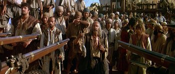 Movie still from “Pirates” (1986), directed by Roman Polanski – A large group of men standing next to each other holding guns; Medium shot, Low angle