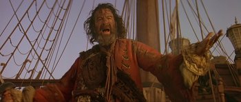 Movie still from “Pirates” (1986), directed by Roman Polanski – A man with a beard is standing on a boat; Medium shot, Low angle