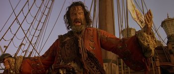 Movie still from “Pirates” (1986), directed by Roman Polanski – A man with a beard is standing on a boat; Close Up shot, Over the shoulder angle