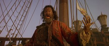 Movie still from “Pirates” (1986), directed by Roman Polanski – A man with a beard and a red jacket is on a boat; Medium shot, Low angle