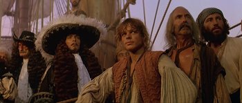 Movie still from “Pirates” (1986), directed by Roman Polanski – A group of people sitting on top of a boat; Medium shot, Over the shoulder angle