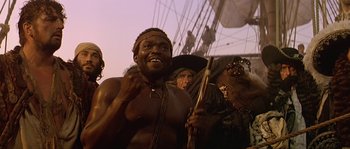 Movie still from “Pirates” (1986), directed by Roman Polanski – A group of people standing next to each other on top of a boat; Medium shot, Low angle