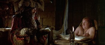 Movie still from “Pirates” (1986), directed by Roman Polanski – An image of a woman sitting on a chair in a room; Medium shot, Over the shoulder angle