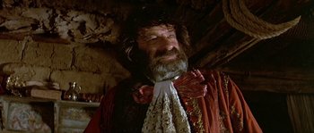 Movie still from “Pirates” (1986), directed by Roman Polanski – An old man with a beard wearing a red and white shirt; Close Up shot, Low angle