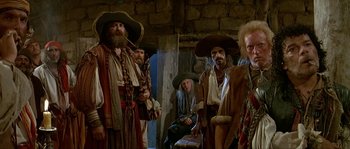 Movie still from “Pirates” (1986), directed by Roman Polanski – A group of men standing next to each other in a room; Medium shot, Low angle