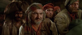 Movie still from “Pirates” (1986), directed by Roman Polanski – A group of men standing next to each other; Close Up shot, Over the shoulder angle