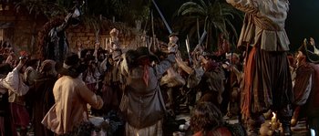 Movie still from “Pirates” (1986), directed by Roman Polanski – A group of people standing in a crowd holding swords; Wide shot, High angle