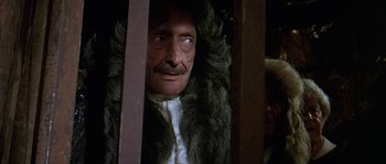 Movie still from “Pirates” (1986), directed by Roman Polanski – A man in a fur coat looking out of a window; Close Up shot, Over the shoulder angle