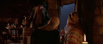 Movie still from “Pirates” (1986), directed by Roman Polanski – A group of people sitting in a room; Medium shot, Over the shoulder angle