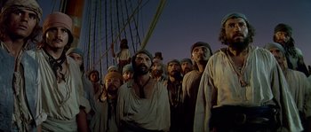 Movie still from “Pirates” (1986), directed by Roman Polanski – A group of men standing next to each other on top of a boat; Medium shot, Low angle