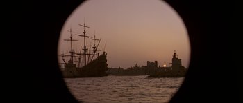 Movie still from “Pirates” (1986), directed by Roman Polanski – A view of a city from a boat at sunset; Extreme Wide shot, Low angle