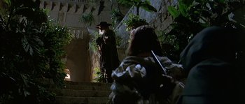 Movie still from “Pirates” (1986), directed by Roman Polanski – A man in a black coat and a woman in a black hat; Wide shot, Low angle