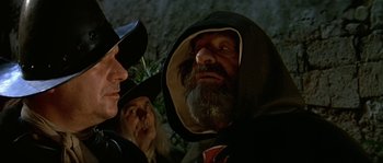 Movie still from “Pirates” (1986), directed by Roman Polanski – A man with a long beard wearing a hooded jacket; Close Up shot, Over the shoulder angle