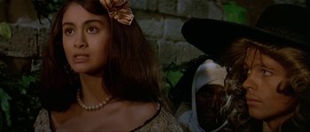 Movie still from “Pirates” (1986), directed by Roman Polanski – A woman with a bow in her hair and a man with a beard and a bow in his hair; Close Up shot, Over the shoulder angle