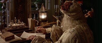 Movie still from “Pirates” (1986), directed by Roman Polanski – An old man writing on a piece of paper in front of a lamp; Medium shot, High angle