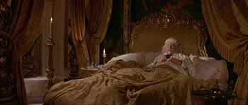 Movie still from “Pirates” (1986), directed by Roman Polanski – An old man laying in a bed next to a lit candle; Wide shot, Overhead angle