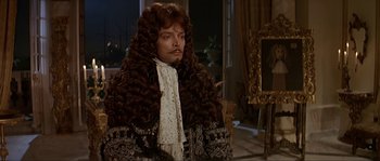 Movie still from “Pirates” (1986), directed by Roman Polanski – A man with a beard and a wig in a room; Medium shot, Over the shoulder angle
