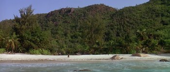Movie still from “Pirates” (1986), directed by Roman Polanski – A person standing on a beach near the ocean; Extreme Wide shot, High angle