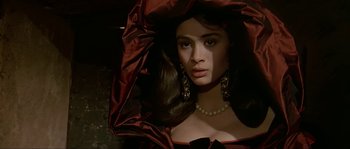 Movie still from “Pirates” (1986), directed by Roman Polanski – A woman in a red dress with a necklace; Close Up shot, Over the shoulder angle