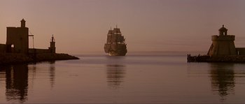 Movie still from “Pirates” (1986), directed by Roman Polanski – A large sail boat in the middle of the ocean at sunset; Extreme Wide shot, Low angle