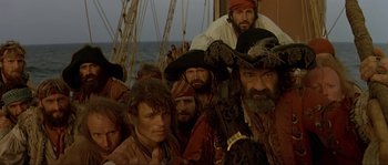 Movie still from “Pirates” (1986), directed by Roman Polanski – A group of people in pirate costumes on a boat; Medium shot, Low angle