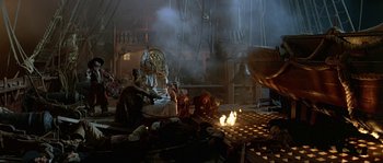 Movie still from “Pirates” (1986), directed by Roman Polanski – A group of people sitting around a fire pit; Wide shot, High angle