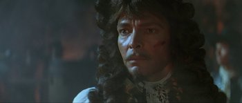 Movie still from “Pirates” (1986), directed by Roman Polanski – A person wearing a wig; Close Up shot, Over the shoulder angle