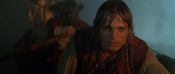 Movie still from “Pirates” (1986), directed by Roman Polanski – A young man with a wet shirt on and a guitar in the background; Close Up shot, Over the shoulder angle
