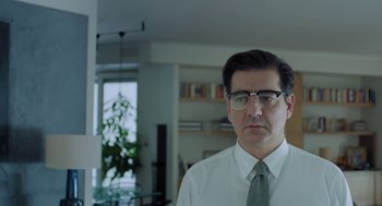Movie still from “Pity” (2018), directed by Babis Makridis – A person wearing glasses and a tie; Close Up shot, Low angle