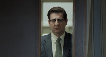 Movie still from “Pity” (2018), directed by Babis Makridis – A man in a suit and tie looking in a mirror; Close Up shot, Over the shoulder angle