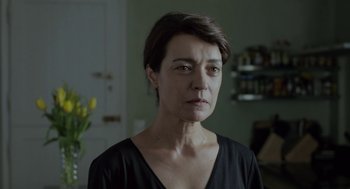 Movie still from “Pity” (2018), directed by Babis Makridis – A person with short hair; Close Up shot, Over the shoulder angle